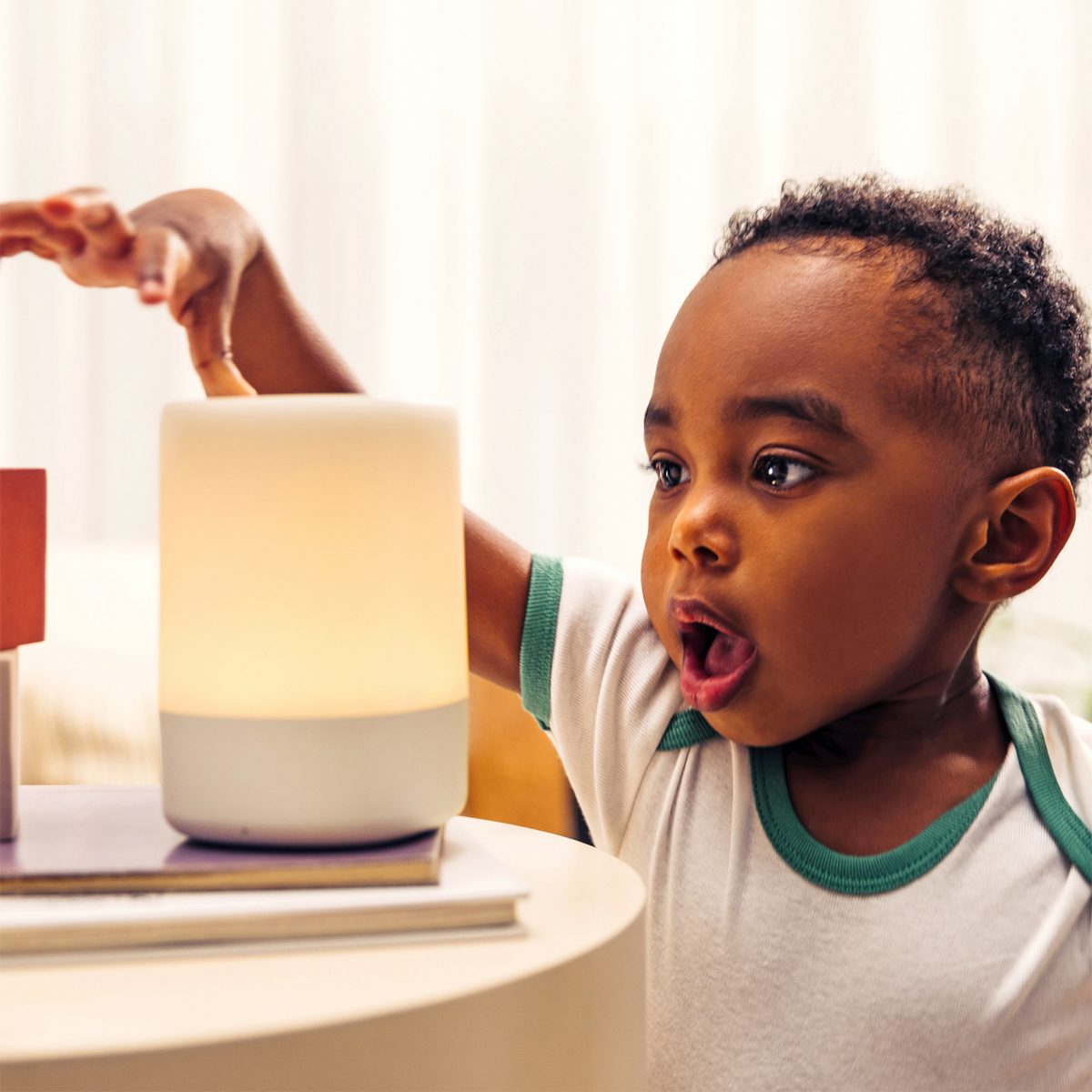#alt_Toddler looking at nanit sound + light with surprised look